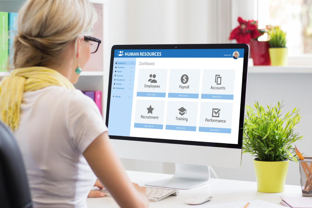 HR professional reviewing an HR system dashboard, not an employee directory